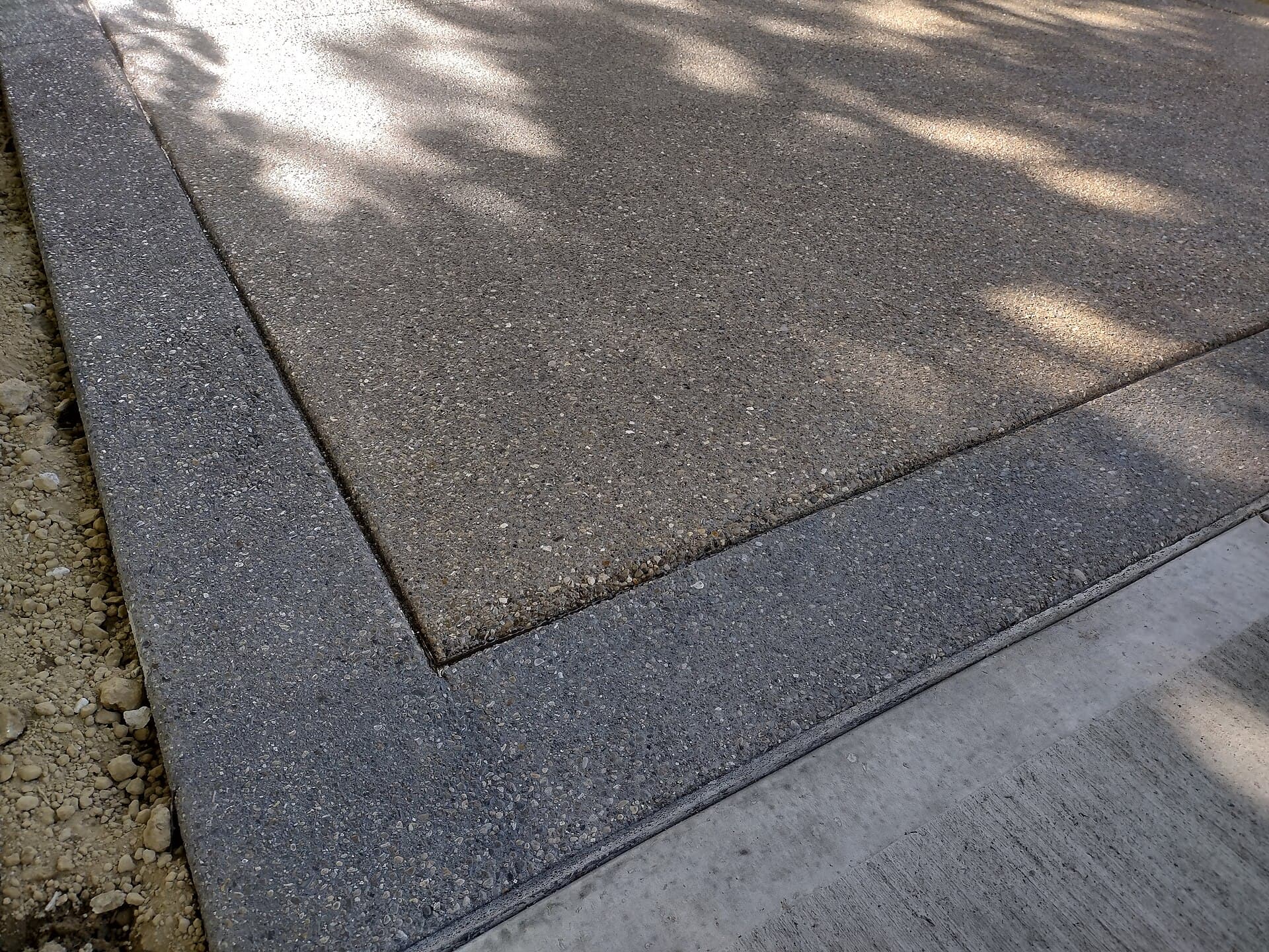 Close-up of exposed aggregate with contrasting sealed borders.