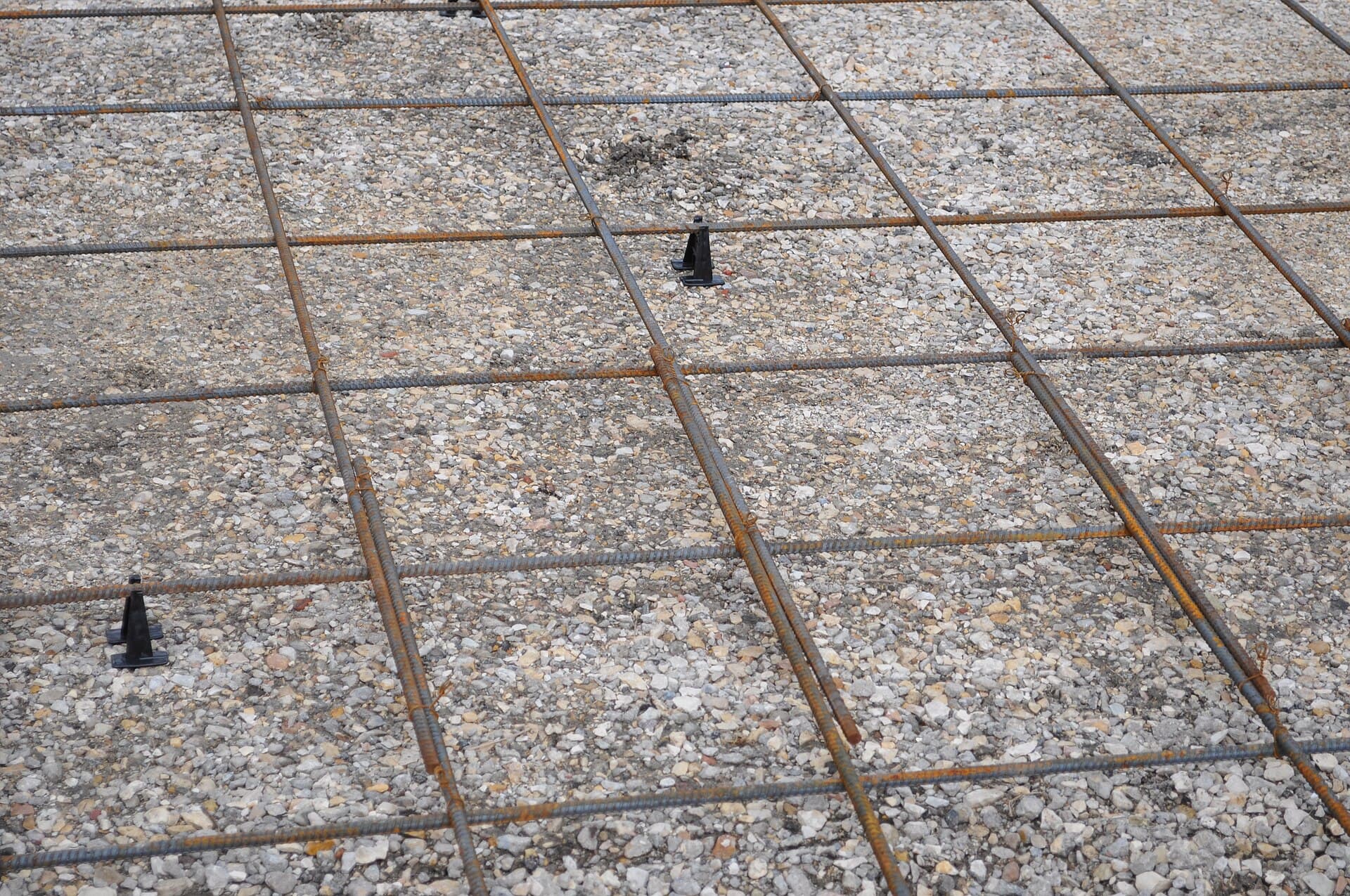 Tied reinforcement on chairs over a gravel bed, ready for a driveway pour.